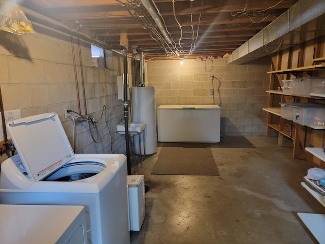 basement featuring water heater, refrigerator, and independent washer and dryer