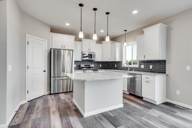 kitchen with a center island, light wood-type flooring, white cabinetry, and stainless steel appliances