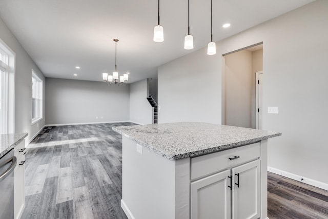 kitchen featuring light stone countertops, dark hardwood / wood-style flooring, white cabinets, and decorative light fixtures