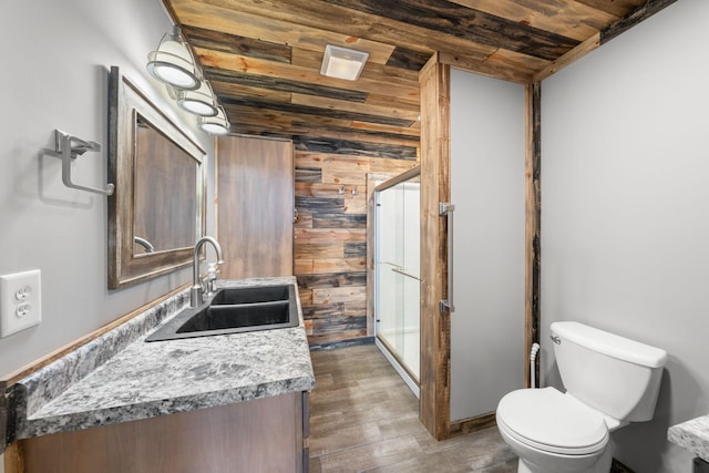 bathroom featuring toilet, wood finished floors, vanity, a stall shower, and wood ceiling