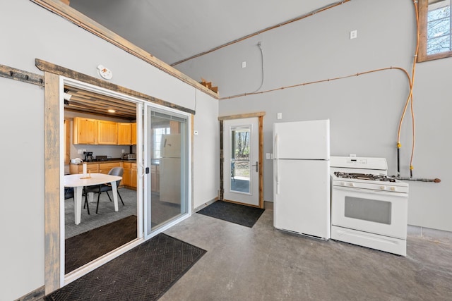 interior space featuring white appliances, concrete flooring, and dark countertops
