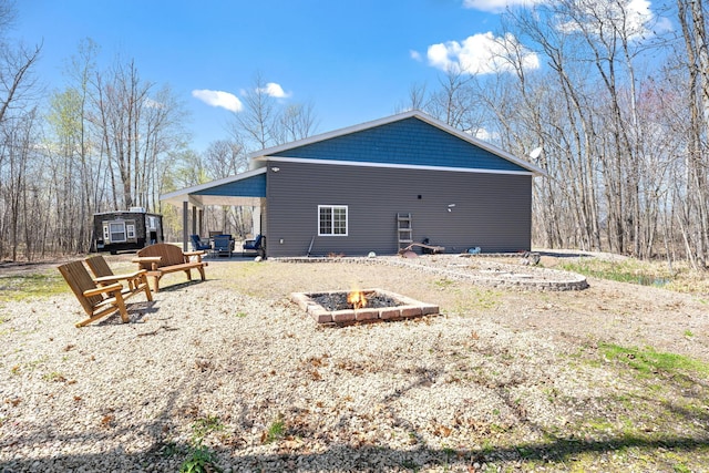 rear view of property with a patio and a fire pit