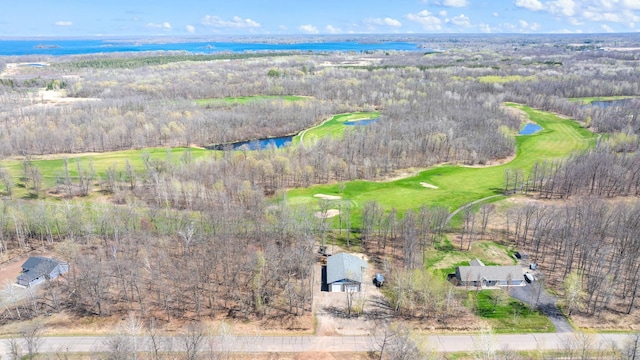 drone / aerial view with view of golf course and a water view
