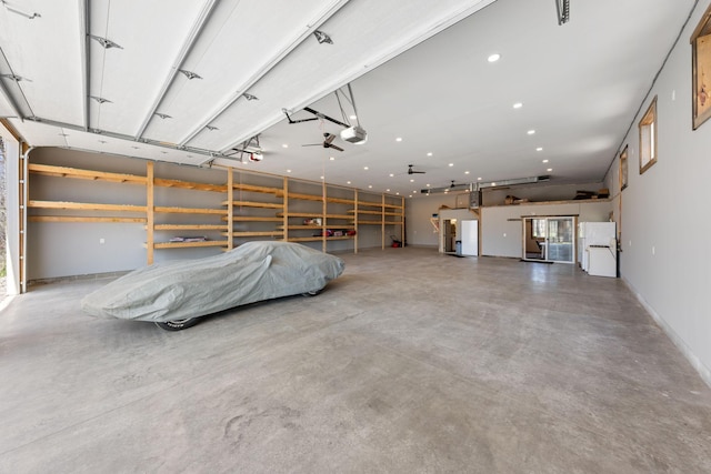 garage with freestanding refrigerator, a garage door opener, and recessed lighting
