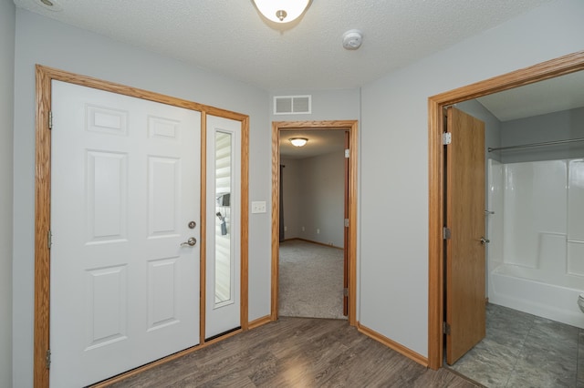 foyer featuring a textured ceiling and dark hardwood / wood-style floors