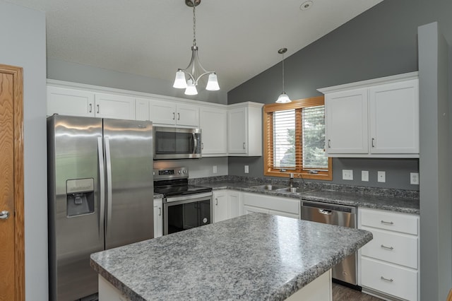 kitchen with decorative light fixtures, a chandelier, white cabinetry, appliances with stainless steel finishes, and vaulted ceiling