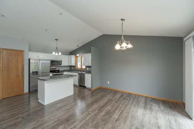 kitchen with pendant lighting, stainless steel appliances, white cabinetry, and a kitchen island