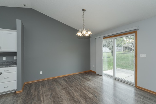 unfurnished dining area with an inviting chandelier, dark hardwood / wood-style floors, and vaulted ceiling