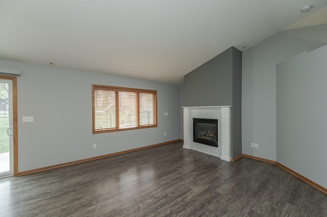 unfurnished living room with lofted ceiling, plenty of natural light, and dark wood-type flooring