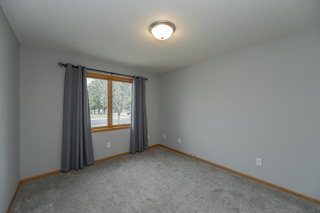 carpeted empty room featuring a textured ceiling