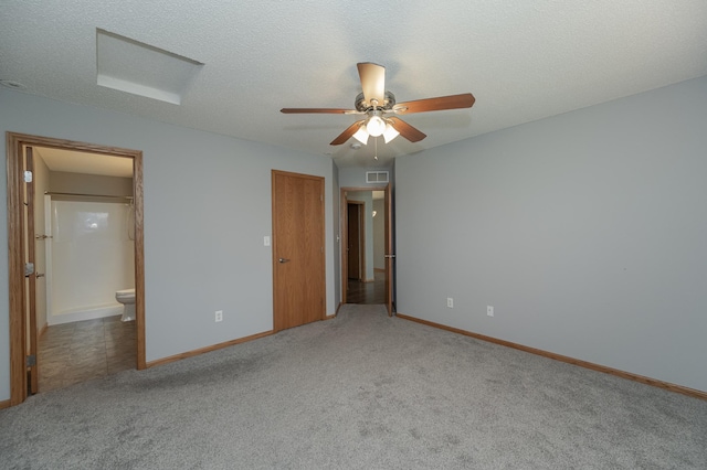 unfurnished bedroom featuring a textured ceiling, ensuite bathroom, ceiling fan, and light colored carpet