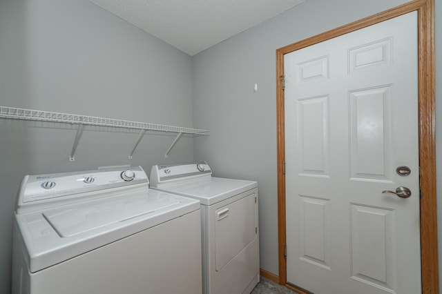 clothes washing area featuring a textured ceiling and washer and clothes dryer