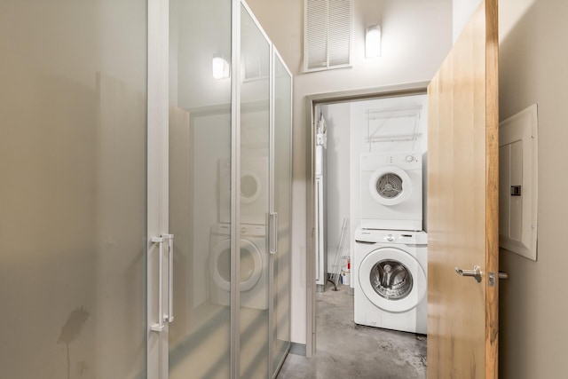 washroom featuring stacked washer / drying machine and electric panel