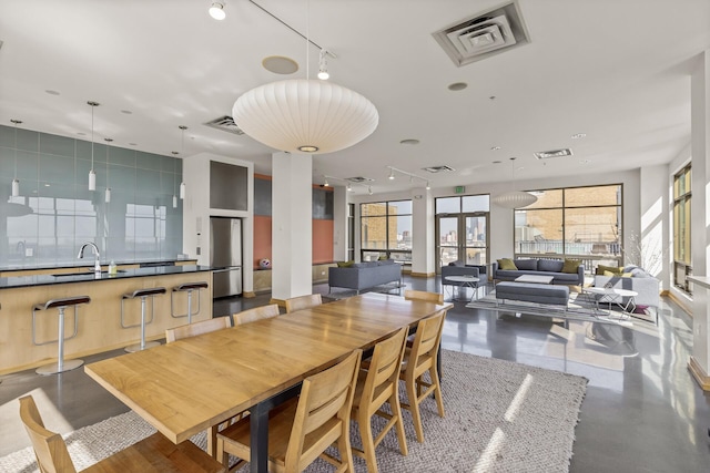 dining area with a wealth of natural light, concrete floors, and sink