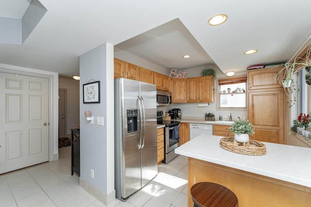 kitchen featuring a sink, light countertops, light tile patterned flooring, and stainless steel appliances