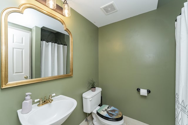 bathroom featuring visible vents, toilet, and a sink