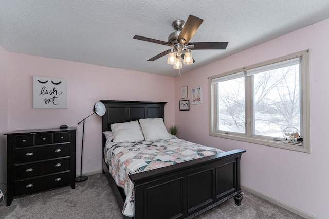 bedroom featuring light colored carpet, baseboards, and a textured ceiling