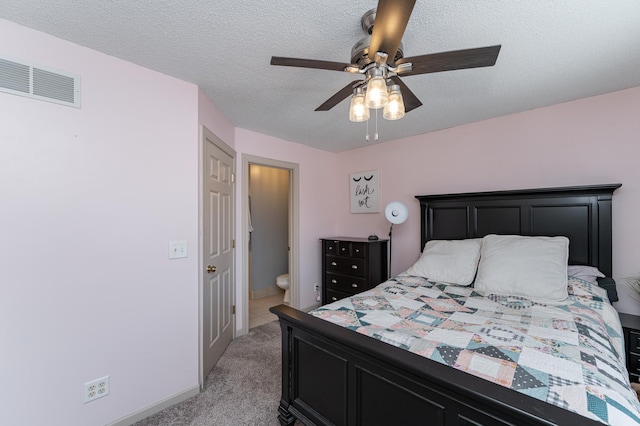 bedroom featuring visible vents, connected bathroom, ceiling fan, light carpet, and a textured ceiling