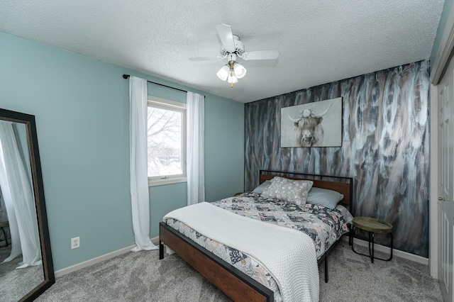 carpeted bedroom featuring a ceiling fan, baseboards, and a textured ceiling