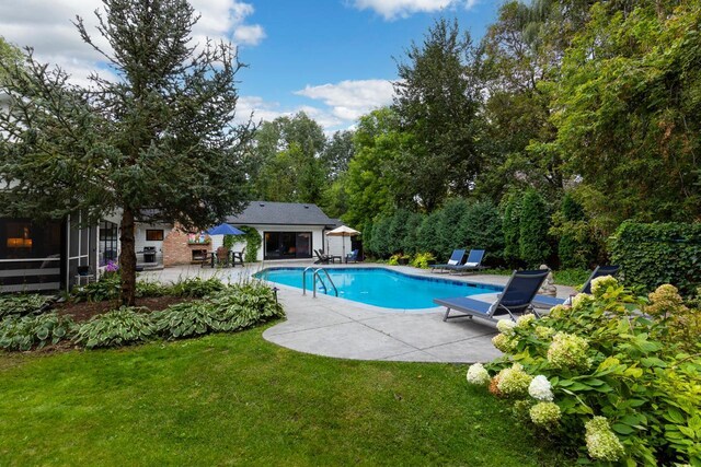 view of pool with a patio area and a lawn