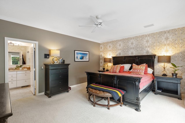 bedroom featuring ornamental molding, ensuite bathroom, light colored carpet, and ceiling fan