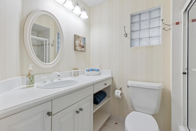 bathroom with vanity, toilet, walk in shower, and tile patterned flooring