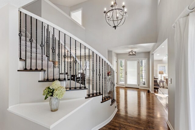 foyer featuring a high ceiling, wood-type flooring, and a chandelier