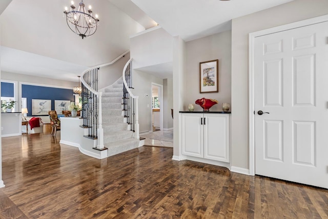 foyer entrance with a notable chandelier and dark hardwood / wood-style floors