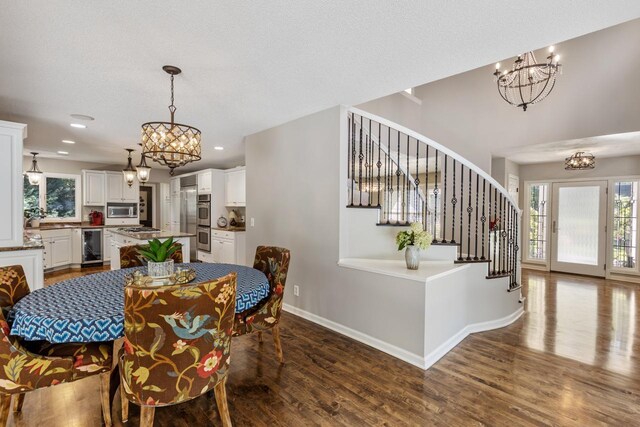 dining room with wine cooler, hardwood / wood-style floors, and a chandelier