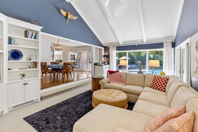 carpeted living room with beamed ceiling and high vaulted ceiling