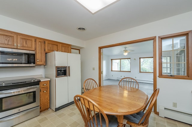 kitchen with appliances with stainless steel finishes, baseboard heating, and ceiling fan