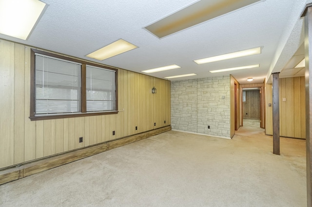 interior space with a textured ceiling and wooden walls