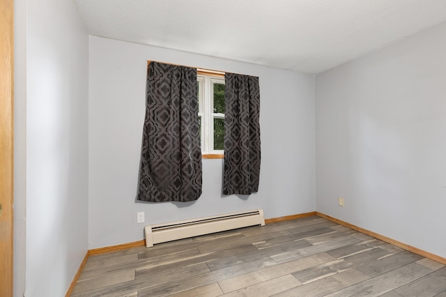 2135 24th Ave SW, Pine River Twp, MN 56474 - empty room featuring a baseboard heating unit, wood finished floors, and baseboards
