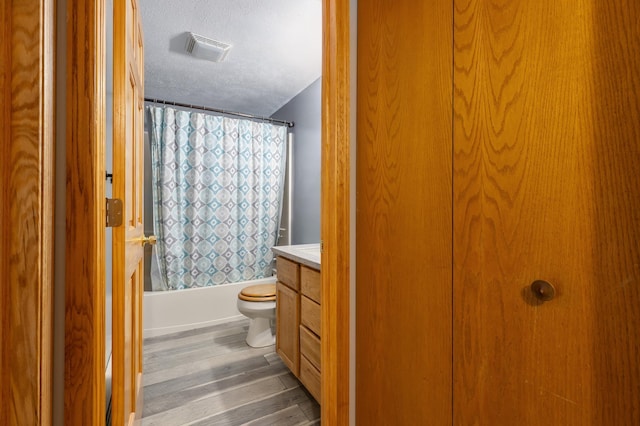 2135 24th Ave SW, Pine River Twp, MN 56474 - full bathroom with vanity, toilet, shower / bathtub combination with curtain, a textured ceiling, and wood finished floors