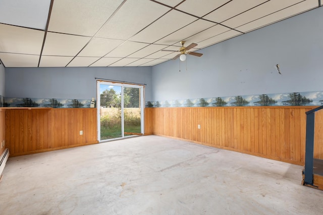 2135 24th Ave SW, Pine River Twp, MN 56474 - unfurnished room with concrete flooring, a ceiling fan, wood walls, a wainscoted wall, and a drop ceiling