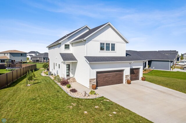 view of front of house with cooling unit, a garage, and a front yard