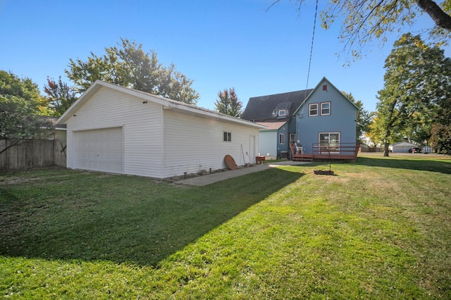 back of house featuring an outbuilding, a yard, a garage, and a deck