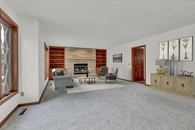 unfurnished living room with light carpet, a stone fireplace, and built in features