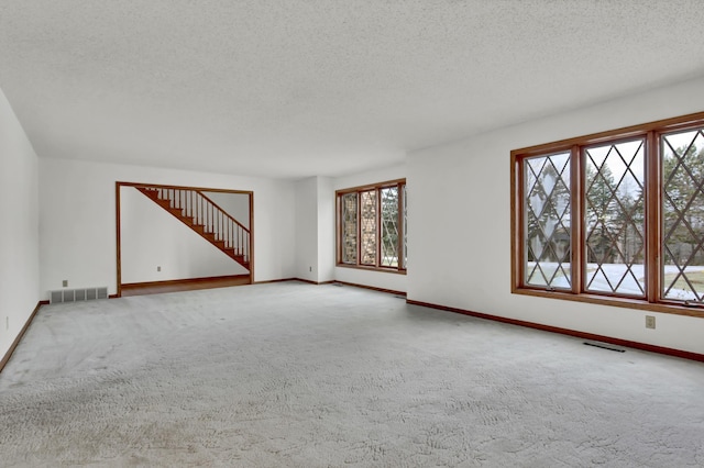 spare room featuring a textured ceiling and carpet