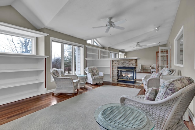 living room with vaulted ceiling, wood-type flooring, ceiling fan, and a fireplace