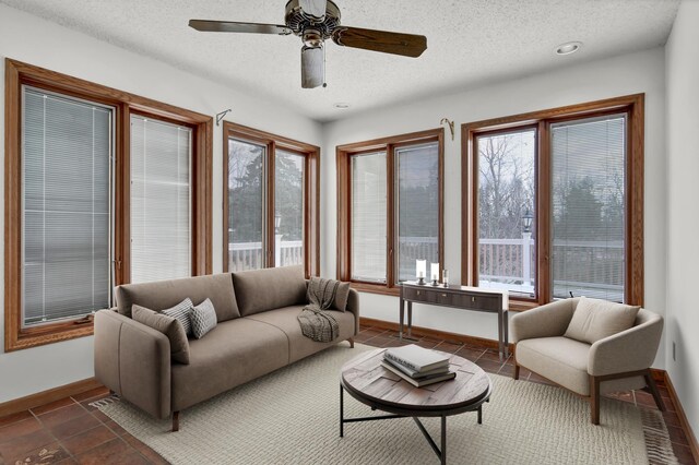 living room with recessed lighting, baseboards, a textured ceiling, and ceiling fan