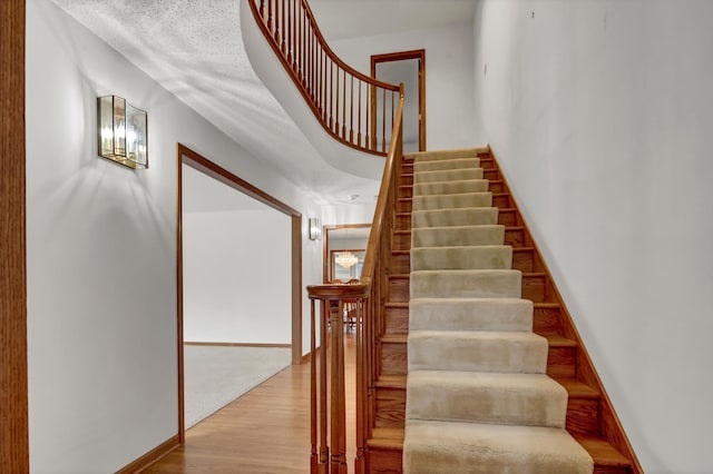 stairs with wood finished floors and baseboards