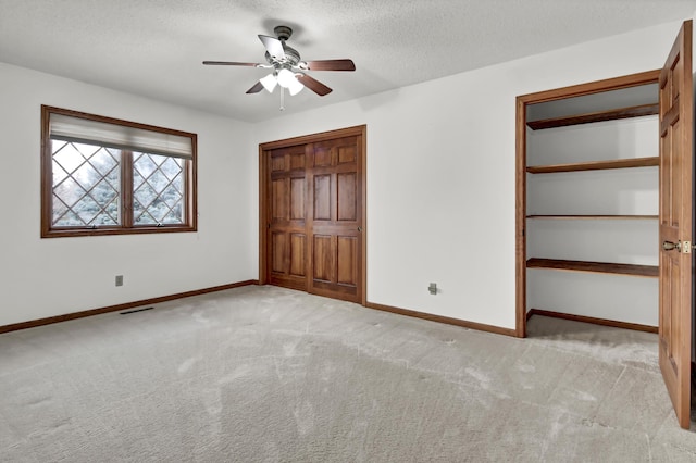 unfurnished bedroom with visible vents, baseboards, carpet, and a textured ceiling