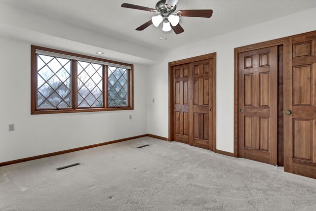 unfurnished bedroom featuring baseboards, visible vents, carpet floors, and a textured ceiling