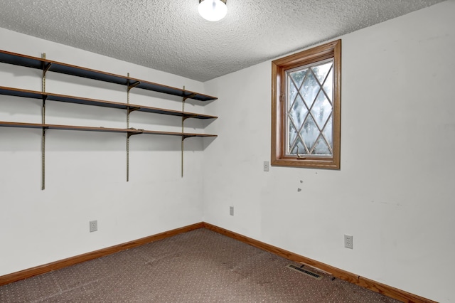 empty room featuring visible vents, baseboards, and a textured ceiling