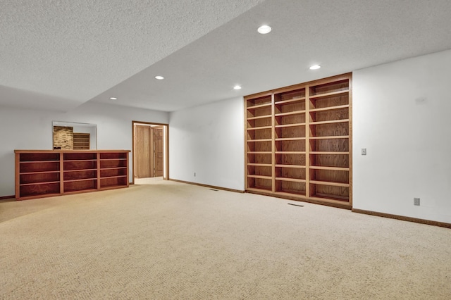 basement featuring recessed lighting, baseboards, a textured ceiling, and carpet