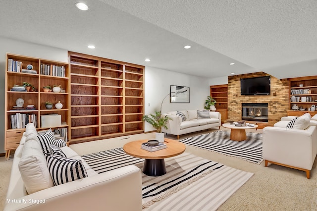 living area with recessed lighting, a brick fireplace, a textured ceiling, and carpet