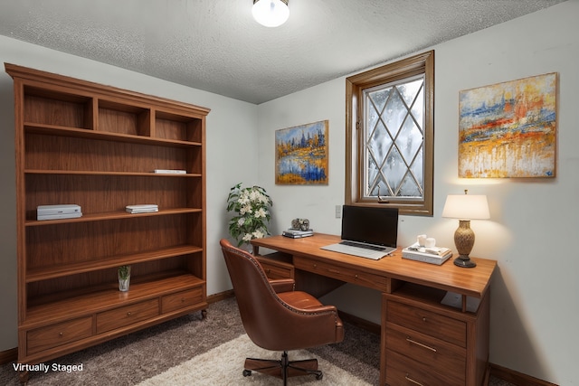 carpeted office with a textured ceiling and baseboards