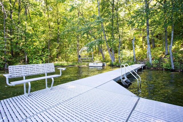 view of dock featuring a forest view and a water view