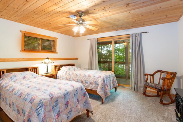 carpeted bedroom featuring ceiling fan, wooden ceiling, and access to exterior